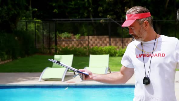 Lifeguard holding clipboard and whistling