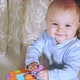 Cute Baby Sits Playing with Developmental Cube Looks at Camera and Laughs Cutely - VideoHive Item for Sale