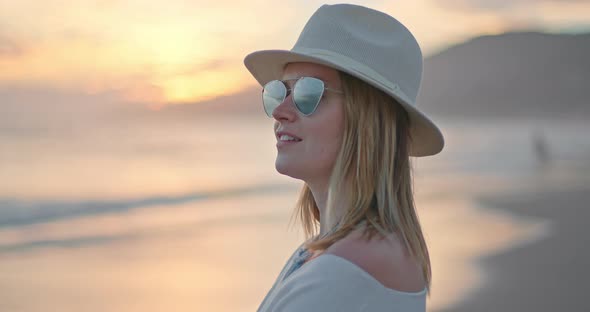 Beautiful Woman Is Enjoying Golden Sunset at Ocean Beach. Traveler in Malibu USA