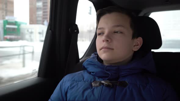 Teenager Looks Out the Car Window in Winter