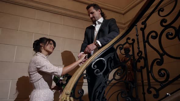 Newlyweds at Wedding Day Adult Man is Kissing Hand of His Beloved Wife Standing on Stair