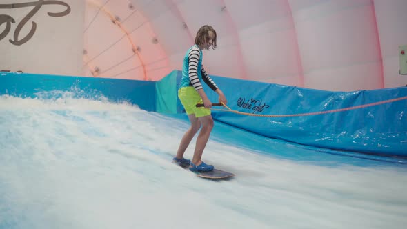 Child and Instructor at Flow Rider Indoor Surfing Training Session