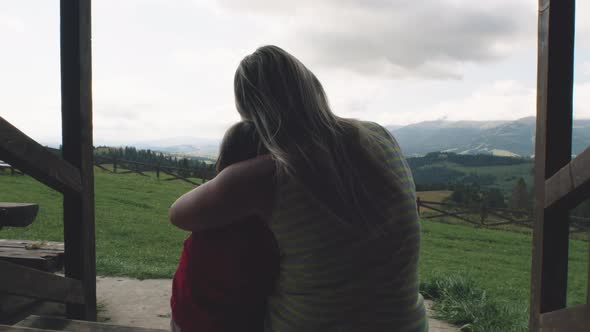 Mother Hugging Daughter on Porch