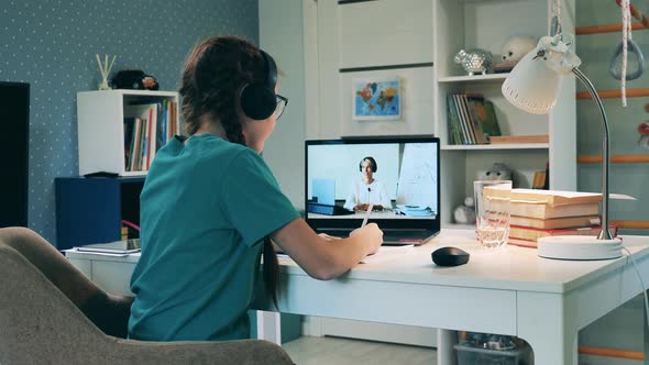 Schoolgirl Studying Remotely at Home Wearing Headphones