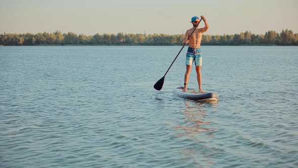 Man Sup Surfing .Stand up Paddling Surfboard. Inflatable Board For Rowing. Surfer Balance Watersport