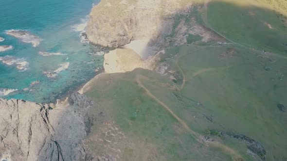 Cinematic aerial drone video of splashing ocean waves into a scenic mountains of Sabtang, Batanes in