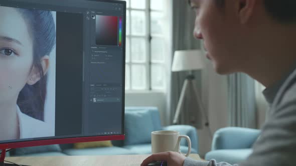 Close Up Of Asian Cameraman Using Desktop Computer For Editing Photos While Working At Home