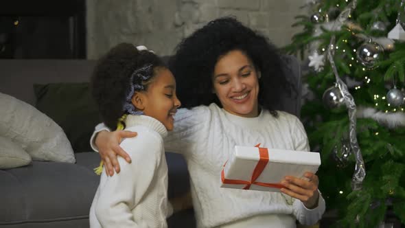 Portrait of a Little African American Girl Surprises Her Mother with a Gift