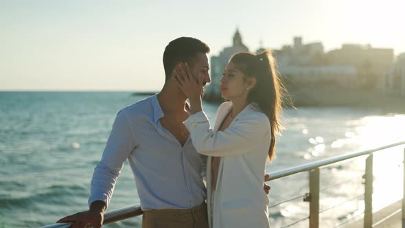 Hispanic Couple Kissing and Talking Against Sea in Town