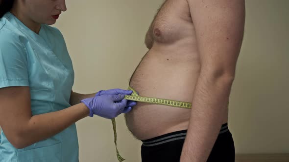 Doctor Measures the Abdominal Circumference of an Overweight Patient