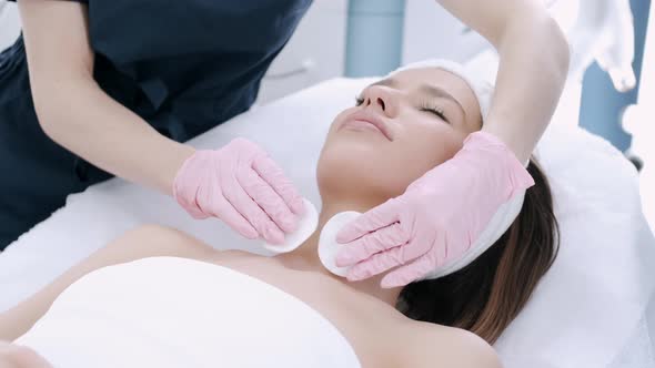 Cropped View of Cosmetologist Cleansing Woman's Skin with Pads