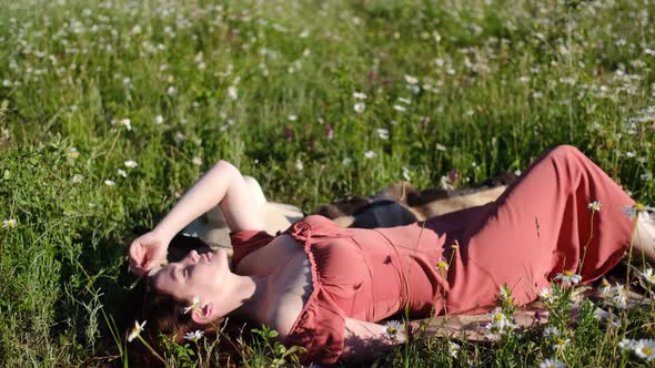 Beautiful Young Woman in Chamomile Field