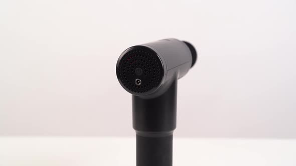 Working Rotating Massage Gun on a White Background