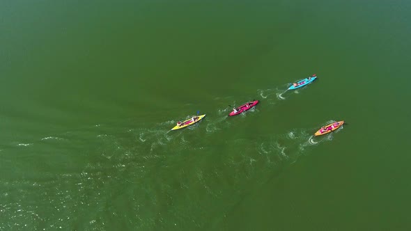 Athletes on Kayaks Competing on Dark Green River Surface