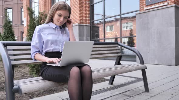 Woman Listening Music and Enjoying Outside Office Building Laptop