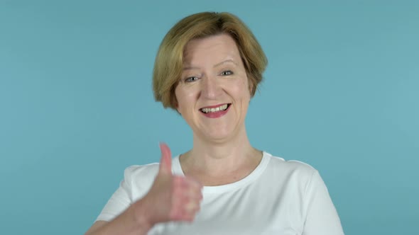 Old Woman Gesturing Thumbs Down Isolated on Blue Background