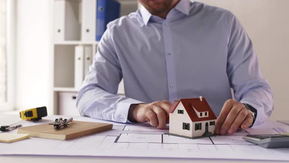 Male Architect with House Model and Blueprint