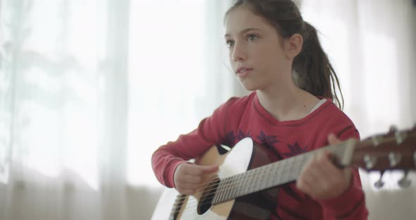 young girl playing guitar and singing