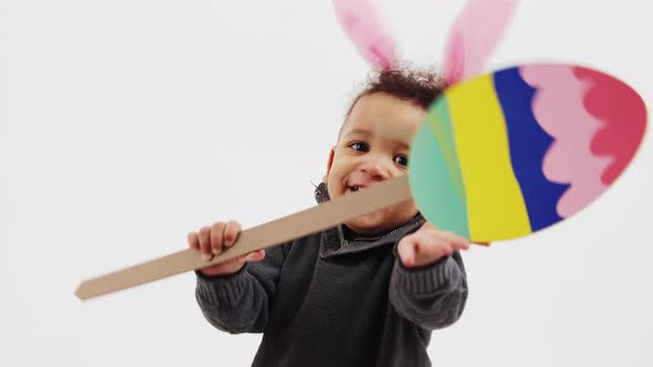 Happy Curly Kid with Bunny Ears and Papermade Easter Egg Medium Closeup Studio Shot Isolated Holiday