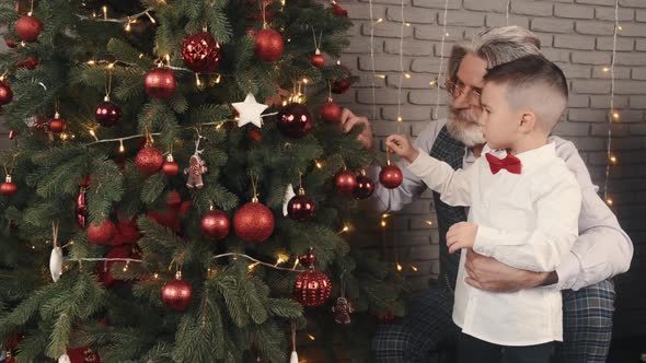 Modern Stylish Grandpa and Kid Decorating Christmas Tree
