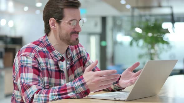 Cheerful Male Designer Talking on Video Call on Laptop 