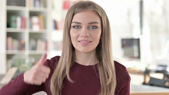 Portrait of Positive Young Woman with Thumbs Up