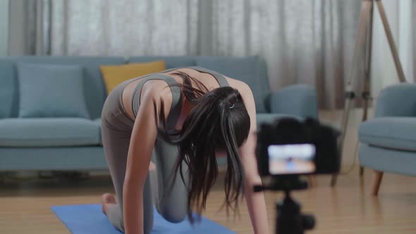 Asian Trainer Female In Sports Clothes Speaking To Camera And Stretching While Recording