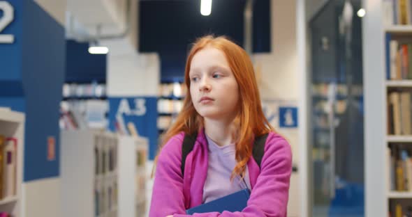 Schoolgirl Walking in Library Choosing Books for Studying