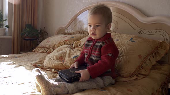 Little Child Sits On The Bed With Bible 2