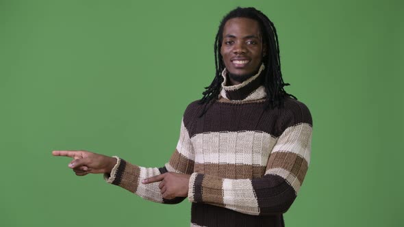 Young Handsome African Man with Dreadlocks Against Green Background