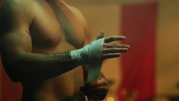 Boxer wrapping bandages on his hand before training