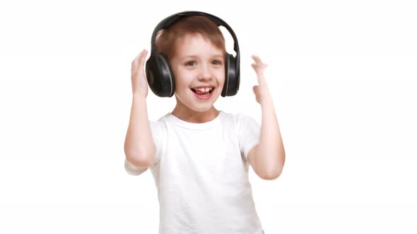 Happy Caucasian Elementaryschool Aged Boy Listening Music Through Black Big Headphones and Waving