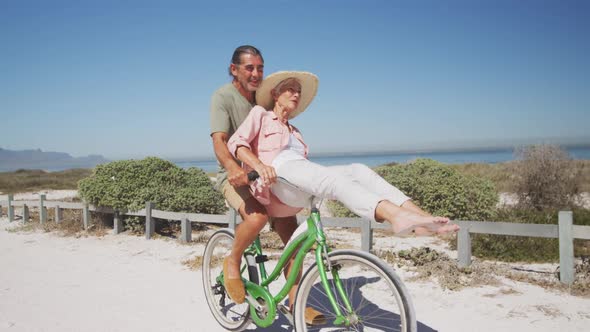 Senior Caucasian couple riding bikes on the beach