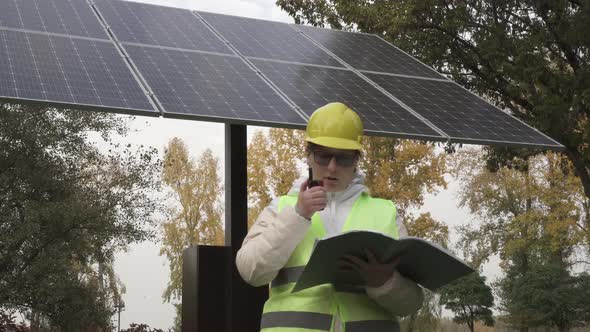 Worker inspects the solar panels and reports the information to the management