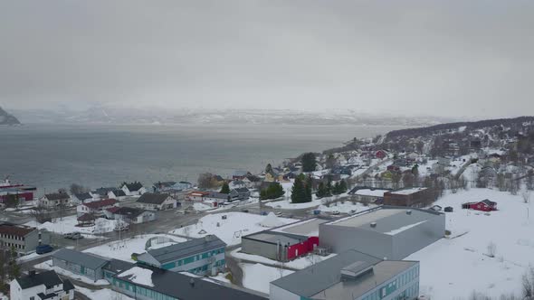 Kåfjord town centre and harbour in Olderdalen, Norway. Overcast winter weather.4K aerial drone shot