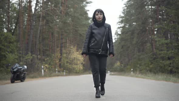 Wide Shot of Confident Beautiful Woman Walking on Empty Road Outdoors. Gorgeous Young Caucasian