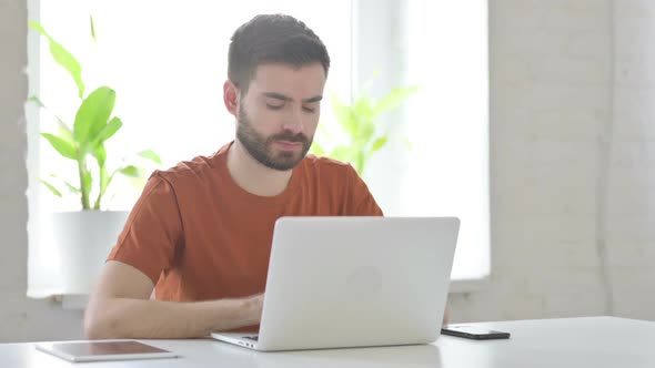 Young Man Thinking at Work in Office