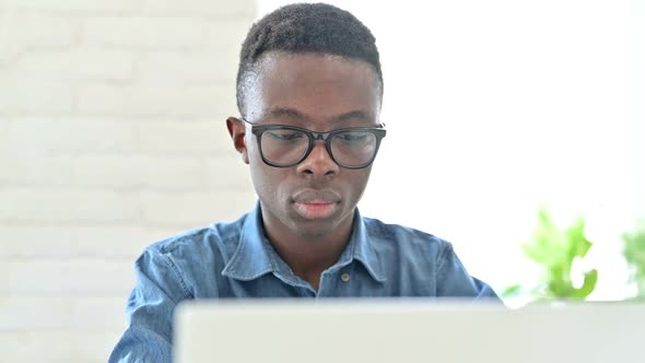 Portrait of Excited Young African Man Celebrating Success on Laptop