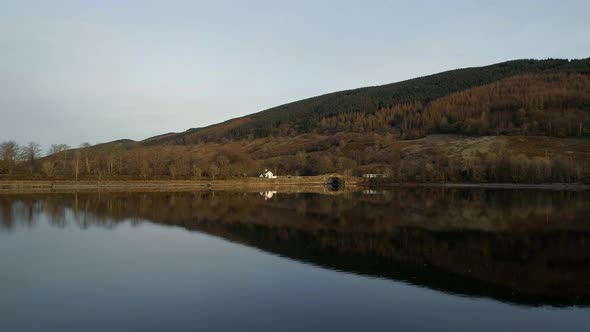 House Reflected in a Still Loch in Scotland