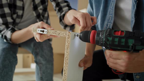 Tilt up video of couple installing bookshelf together. Shot with RED helium camera in 8K