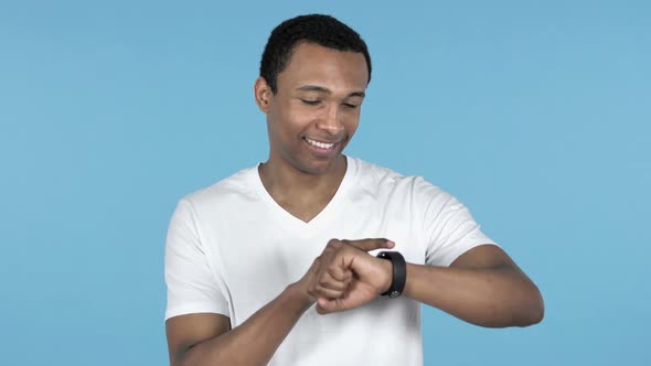 Young African Man Using Smartwatch Blue Background