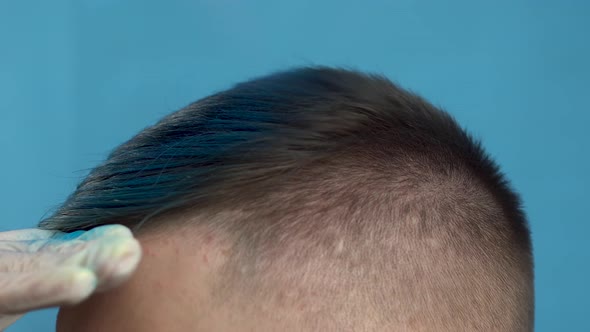 A Young Man Is Dyed His Hair Blue Closeup. A Alternative People Is Painted with Temporary Hair Dye
