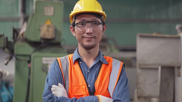 Portrait Asian male engineer in safety clothing smiling to camera.
