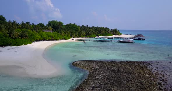 Natural flying tourism shot of a white sandy paradise beach and aqua turquoise water background