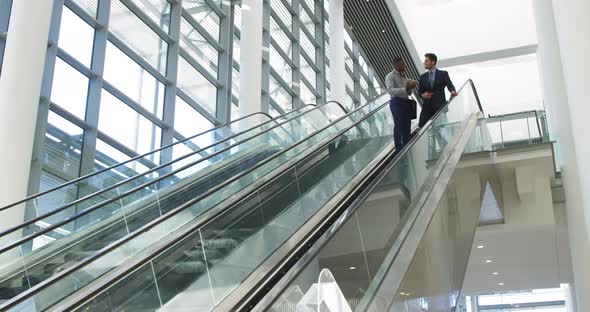 Young business people on an escalator in a modern building