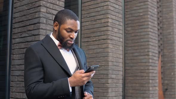 Elegant Bearded African American Businessman Talking on Phone Near the Office Center