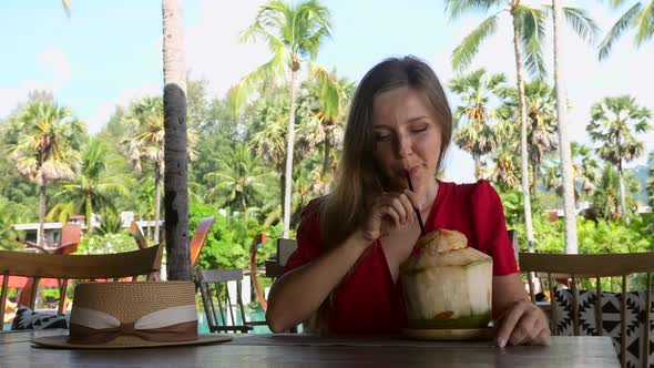 Happy Traveler Woman Relax in Cafe with Young Coconut on Beach with Palm Trees