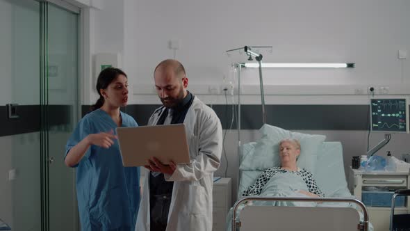 Doctor with Laptop Discussing with Nurse Before Consultation