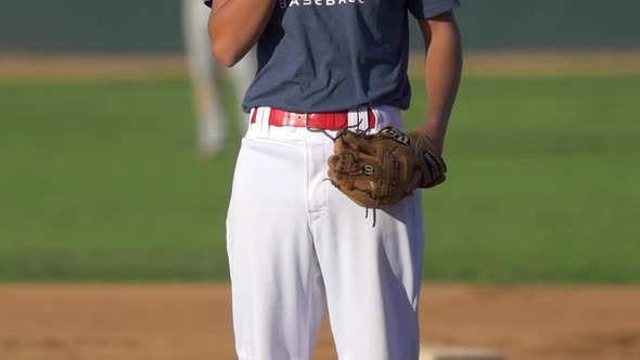 The pitcher at a baseball game throws the ball to the batter.