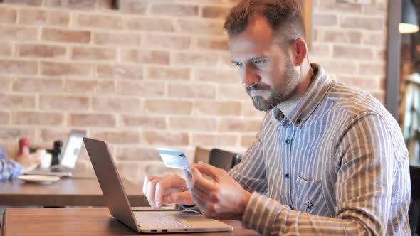 Online Shopping on Laptop by Young Man